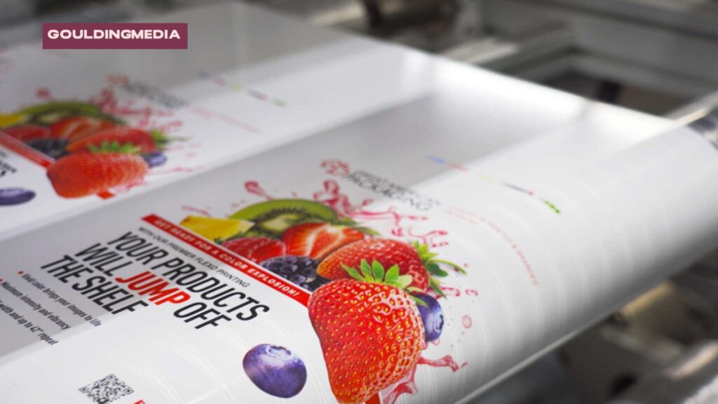 Flexographic printing press producing colourful fruit-themed packaging labels on a continuous roll.