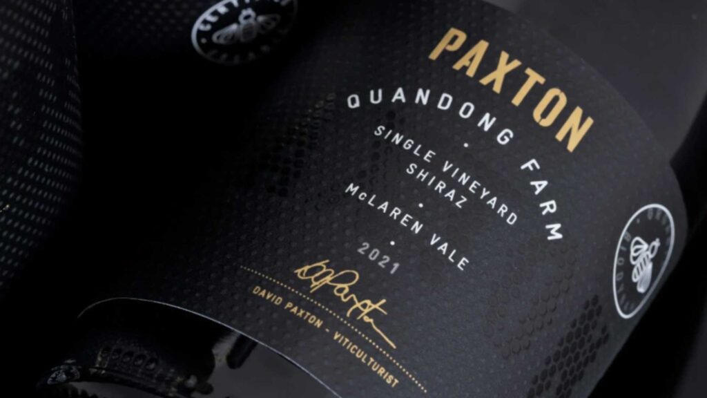 Matte black wine bottle label with minimal gold foil typography and refined design.
