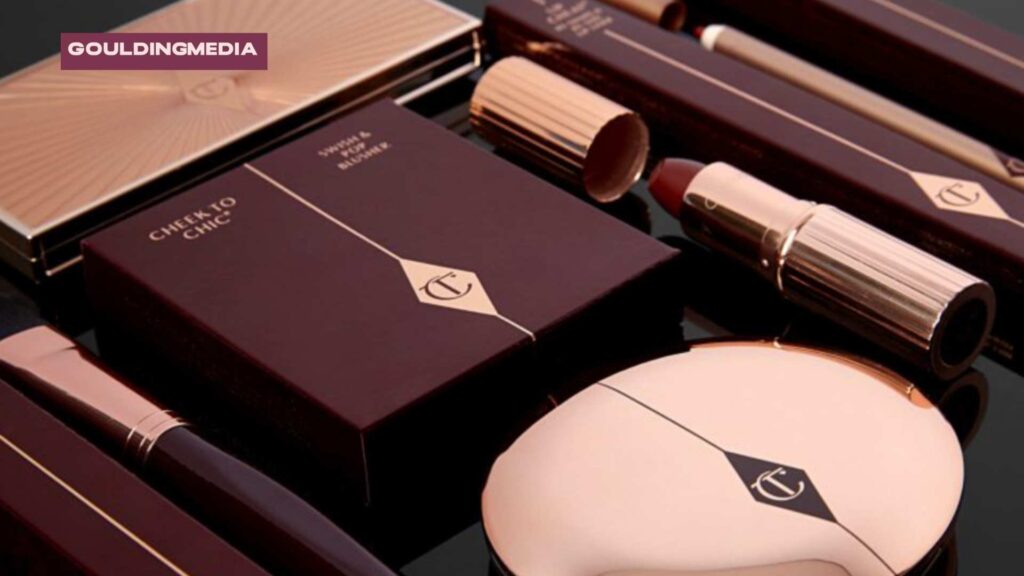 A flat lay of Charlotte Tilbury make-up products, including a compact, lipsticks, and palettes in deep burgundy packaging.