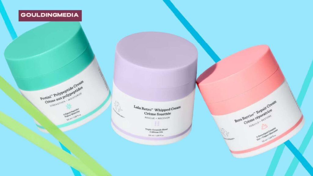 Colourful Drunk Elephant product jars floating against a vibrant aqua background with bold diagonal stripes.