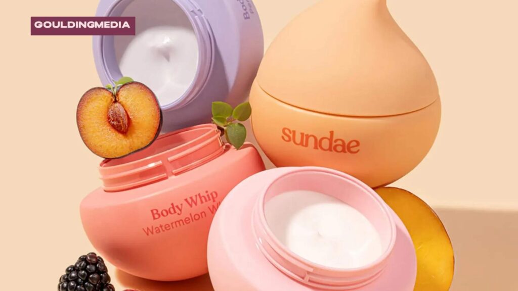 Sundae peach-scented body whip in open jar with playful packaging and fresh peach props.