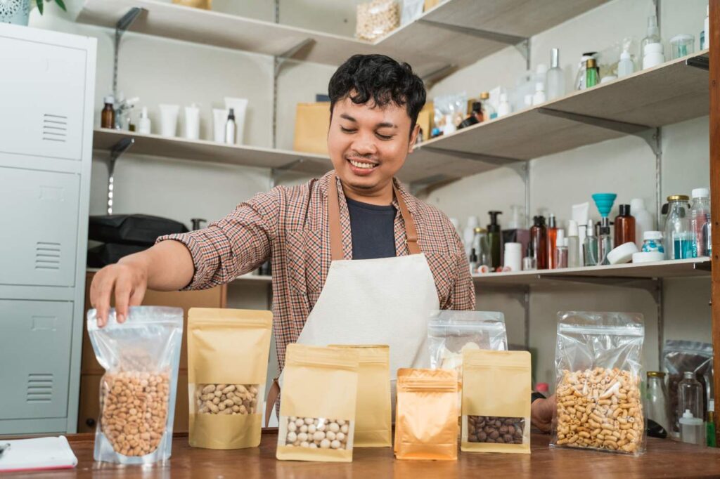 A smiling shopkeeper packing dry goods in a small-scale shop, with various eco-friendly packages on display.