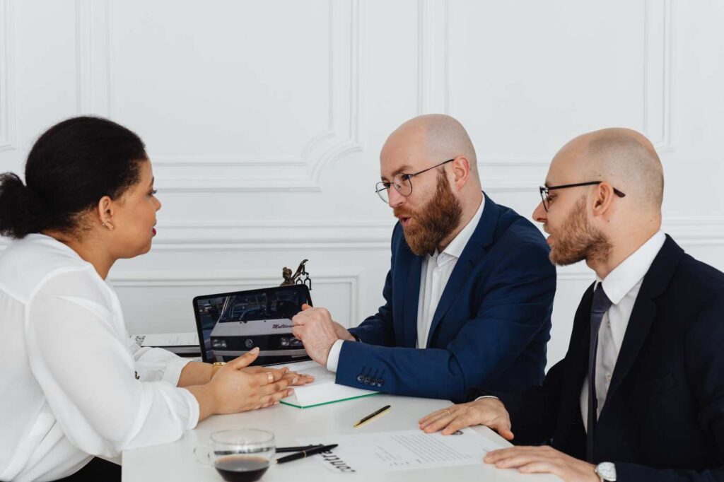 Professionals reviewing information on a tablet during a formal meeting.