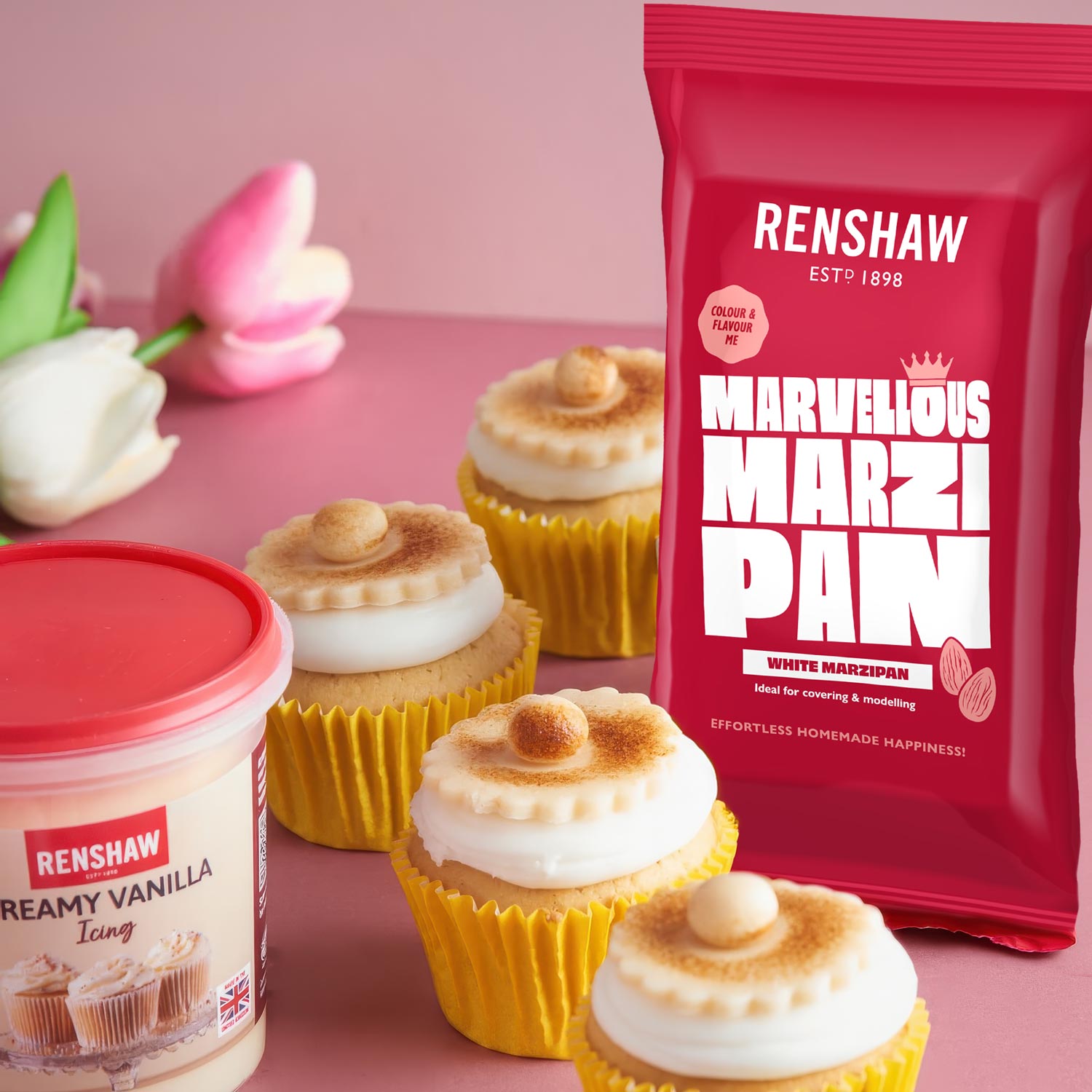 Renshaw Ready to Roll Marzipan in red packaging displayed upright with a wooden rolling pin, pastry brush and cutters arranged on a light baking surface