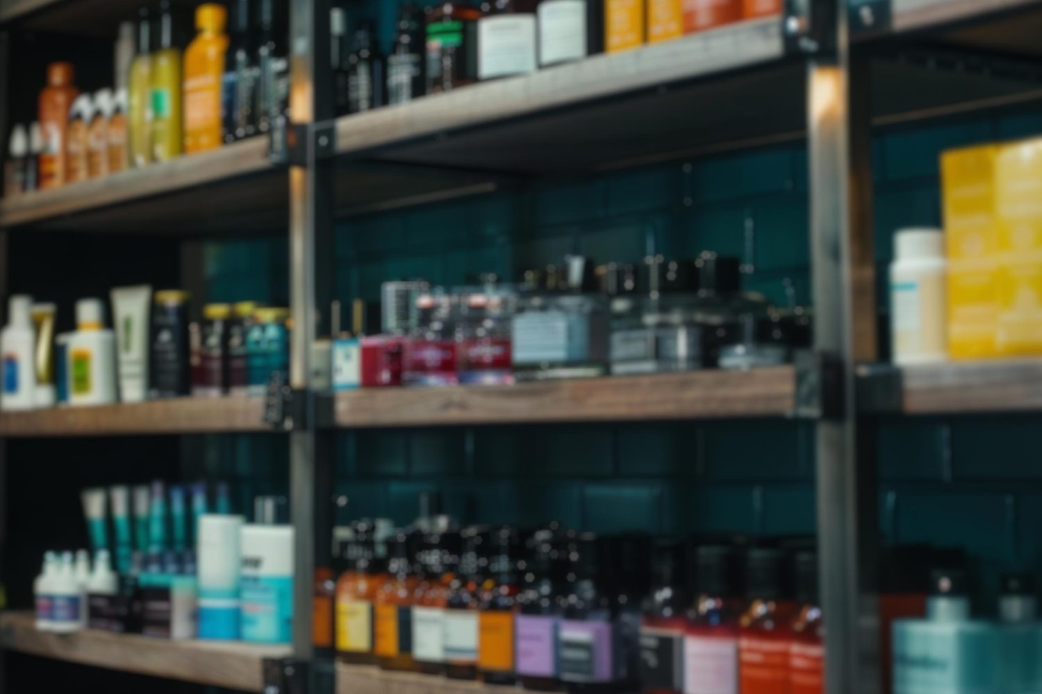 An assortment of shampoo and haircare products in various bottles arranged on store shelves. The selection includes different brands and packaging, neatly organized by size and color.