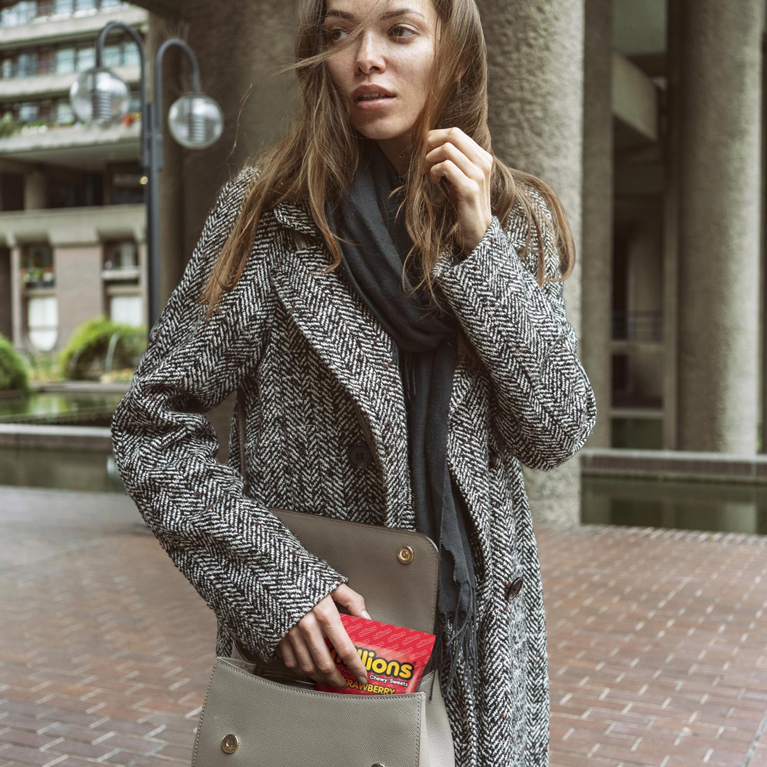 Young Woman with new Millions Sweets Packaging Refresh in Handbag